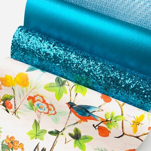 May include: Four different teal coloured fabric swatches. The top swatch is a light blue woven fabric. The second swatch is a solid teal fabric. The third swatch is a teal glitter fabric. The bottom swatch is a white fabric with a floral pattern and birds.
