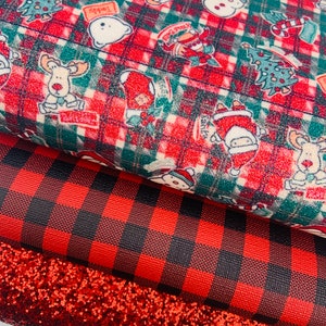 May include: Three pieces of fabric: a red and green plaid fabric with a Christmas theme, a red and black buffalo plaid fabric, and a red glitter fabric.