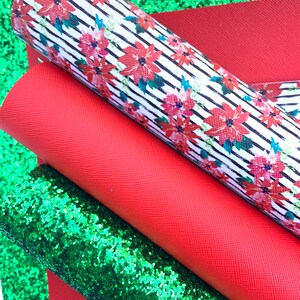 May include: A set of three fabric sheets in red, green, and white. The white sheet has a black and white striped pattern with red poinsettia flowers. The red sheet is a solid color. The green sheet is a sparkly glitter fabric.