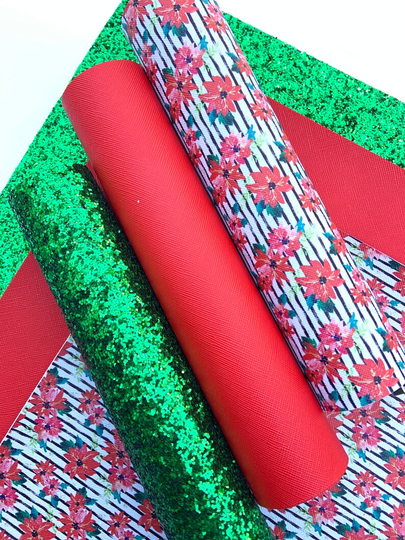May include: Three rolls of fabric for crafting projects. One roll is red, one is green glitter, and one has a white and black striped pattern with red poinsettia flowers.