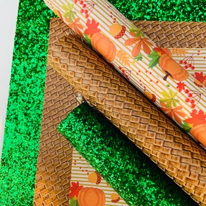 May include: An assortment of decorative craft materials, including rolls of patterned fabric and glitter sheets. The fabrics feature autumn-themed designs with pumpkins, leaves, and berries. The color palette includes green, brown, orange, and white.