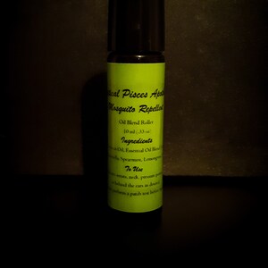 May include: A 10 ml mosquito repellent oil blend roller bottle with a black cap and a light green label. The label features black text reading Mystical Pisces Apothecary, Mosquito Repellent, Oil Blend Roller, Ingredients, and To Use instructions.