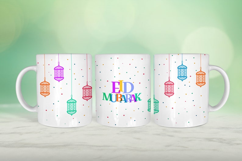 May include: Three white ceramic mugs with colourful Eid Mubarak text and hanging lanterns on a white background. The mugs have a white background with colourful polka dots.