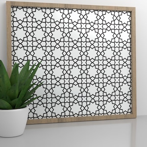 Peut inclure: Une impression géométrique noire et blanche encadrée avec un motif d'étoile répété. Le cadre est en bois et a une finition brun clair.