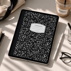 May include: A digital tablet displaying a black and white speckled composition notebook cover design with a central white label featuring the text COMPOSITION and MY PLANNER, surrounded by a beige tote bag, notebooks, a coffee cup, and glasses.