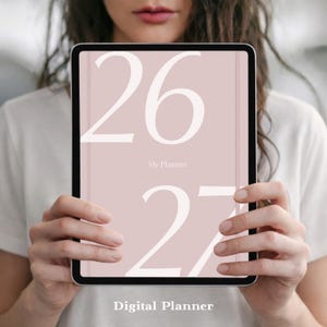 May include: A digital tablet displaying a planner cover with a dusty rose background. The cover features large white serif numerals 26 and 27, with the text My Planner centered between them. The words Digital Planner appear at the bottom.