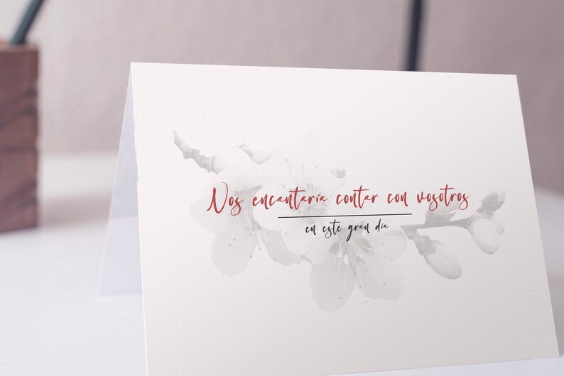 Op de afbeelding: Een witte kaart met een aquarel bloemenontwerp en de tekst "Nos encantar&iacute;a contar con vosotros en este gran d&iacute;a" in rood.
