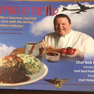 May include: A book cover with a blue background and a white airplane flying in the sky. The title of the book is "Affair in the Air: Why a Gourmet Chef Fell in Love with the Airline Services Industry". The author is Chef Bob Rosar. The book cover also features a photo of a chef holding a plate of food.