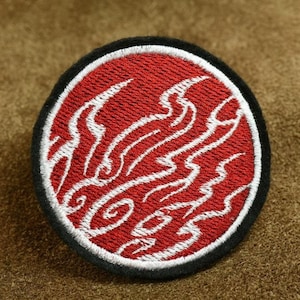 May include: A red and white embroidered patch with a wave design. The patch is circular and has a black border.