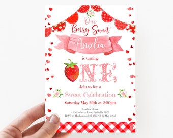 Puede incluir: Una invitación de cumpleaños rosa y roja con una fresa y el número uno. La invitación dice "Our Berry Sweet Amelia is turning One. Join us for a Sweet Celebration Saturday May 29th at 2:00pm. Amelia's House 44 Strawberry Lane, Fruitville 7622. RSVP to Madison on 123 456 789 by May 22nd."