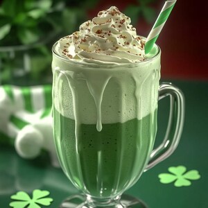 Può includere: Una bevanda di caffè freddo verde e bianco con panna montata e granella di cioccolato in una tazza di vetro trasparente con manico.