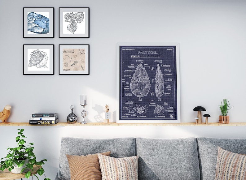 Pode incluir: Uma impress&atilde;o emoldurada de uma ilustra&ccedil;&atilde;o desenhada &agrave; m&atilde;o de um machado de m&atilde;o, tamb&eacute;m conhecido como 'Faustkeil', sobre um fundo azul. A impress&atilde;o &eacute; cercada por uma moldura branca e est&aacute; pendurada em uma parede branca acima de uma prateleira com livros, itens decorativos e um sof&aacute; cinza.