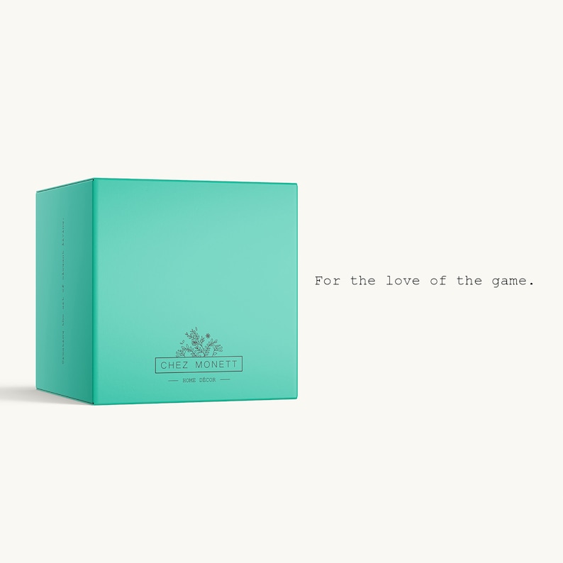 May include: A teal box with the text "Chez Monett" and a small floral design. The text "For the love of the game." is printed below the box.