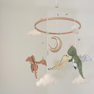 Handmade dragon-themed baby mobile featuring felt dragons, clouds, a golden moon, and tiny stars, perfect for a fantasy-inspired nursery decor.