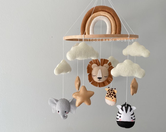 Safari nursery mobile with lion elephant giraffe zebra rainbow gold stars and cloud. Neutral gender baby mobile in beige gold color palette