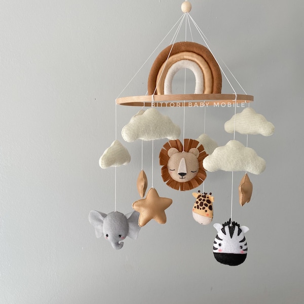 Safari nursery mobile with lion elephant giraffe zebra rainbow gold stars and cloud. Neutral gender baby mobile in beige gold color palette