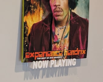 May include: A vinyl record cover featuring Jimi Hendrix with a fiery background. The album title is "Experience Hendrix: The Best of Jimi Hendrix" and the text "Now Playing" is displayed below the album cover.