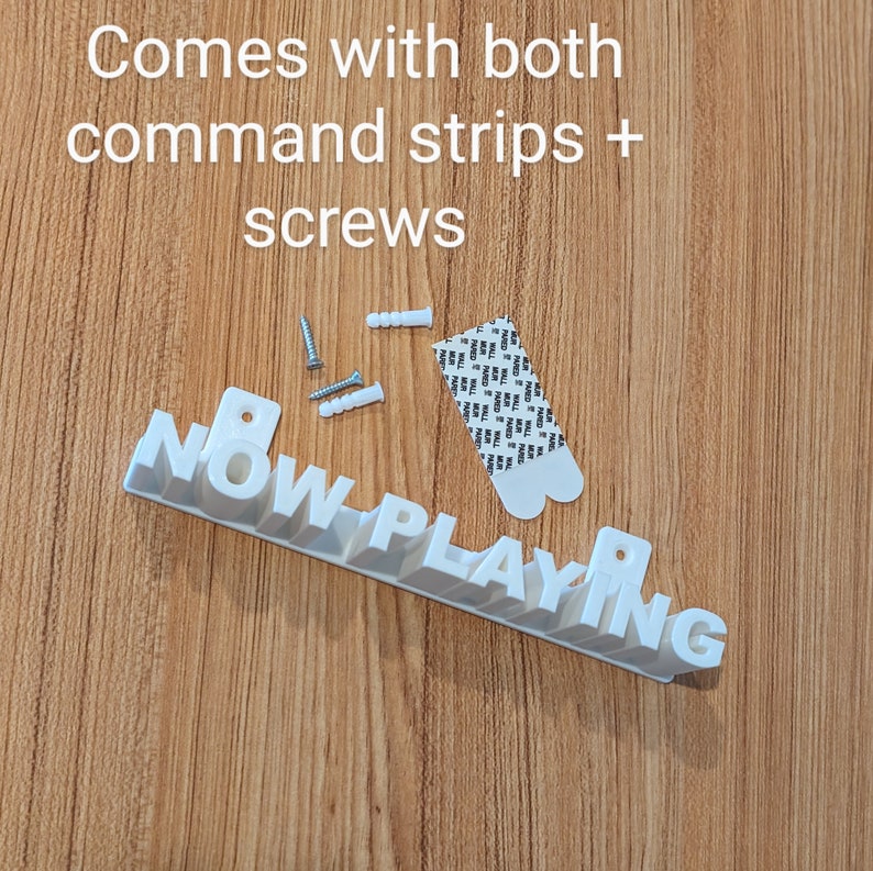 May include: White plastic sign that reads "NOW PLAYING" with screws and command strips for hanging.