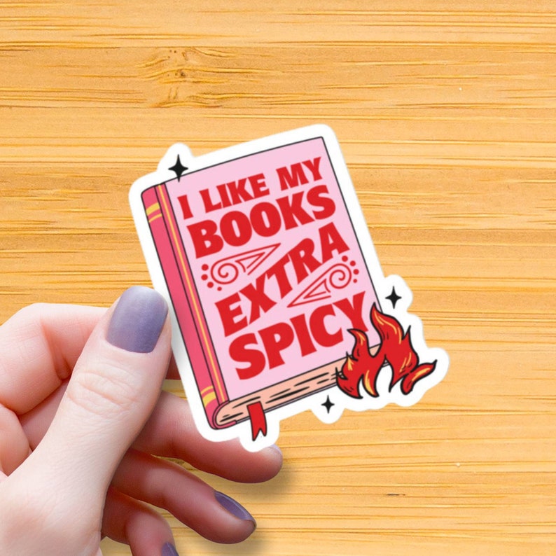 May include: A pink and red sticker with a book illustration and the text "I like my books extra spicy".