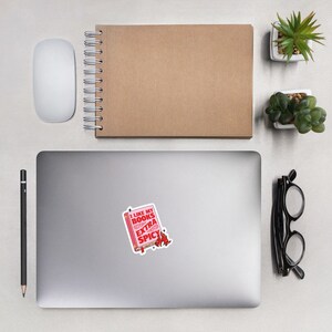 May include: A pink and red sticker with a book illustration and the text "I like my books extra spicy".