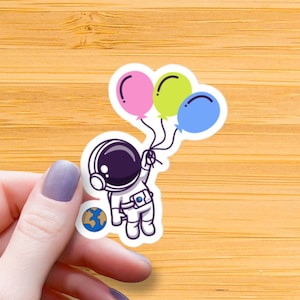 Astronauta galleggiante che tiene il palloncino adesivo lucido impermeabile, adesivo in vinile spaziale, adesivo per astronauti carino, adesivi per palloncini, regalo per bambini