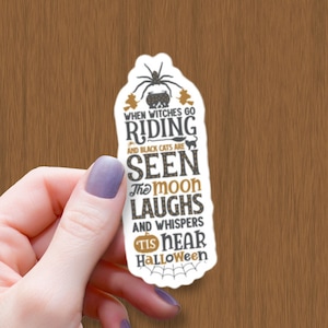 May include: A white sticker with a black spider, a cauldron, and bats. The text reads "When witches go riding and black cats are seen the moon laughs and whispers 'tis near Halloween."