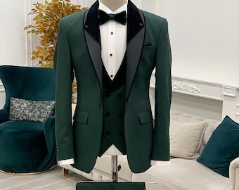 May include: A dark green tuxedo suit with a black satin lapel and a matching vest. The suit is displayed on a mannequin and includes a pair of matching pants.