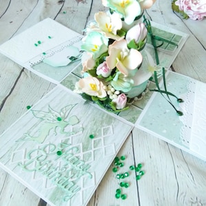 May include: A white box with a green and white floral design. The box is open and the inside is decorated with a green and white floral design. The box is decorated with green and white rhinestones. The box says "Happy Birthday" on the front.