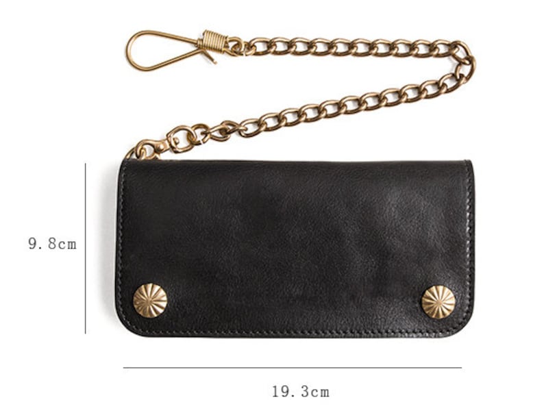 May include: Black leather wallet with a chain and two brass studs. The wallet measures 9.8 inches by 19.3 inches.