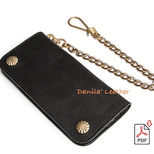 May include: Black leather wallet with a gold chain and brass accents. The wallet has two decorative studs on the front. "Danila' Leather" is printed on the wallet.