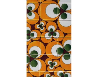 May include: A rectangular arrangement of fifteen square ceramic tiles featuring a repeating graphic pattern of large orange circles, smaller white circles, and dark green circular centres set against a deep brown background.