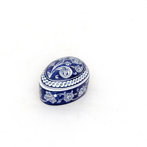 May include: A blue and white ceramic trinket box shaped like an egg with a floral design.