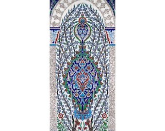 May include: A traditional Turkish tile design featuring a stylised tree with blue, green, red, and white floral patterns. The tile is framed by a white archway with a blue border.