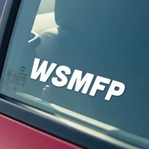 May include: A red car door with a window displaying the white text "WSMFP". The interior of the car is visible through the window, including a seat and dashboard.