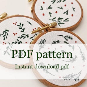 Puede incluir: Tres aros de bordado con tela blanca y diseños de bordado verde y rojo. Los aros están sobre un fondo verde. El texto "PDF pattern" y "Instant download pdf" está en la imagen.
