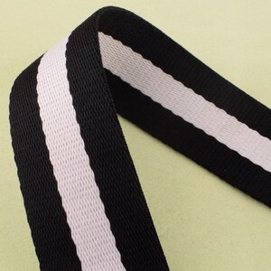 May include: Black and white striped webbing with a textured surface.
