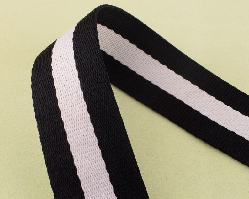 May include: Black and white striped webbing with a textured surface.