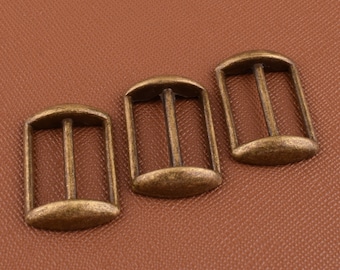 May include: Three antique gold-toned metal slider buckles. Each buckle has a rectangular shape with rounded edges and two parallel bars in the center.