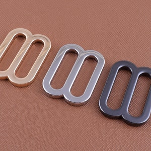 May include: Three metal slider buckles in gold, silver, and black.