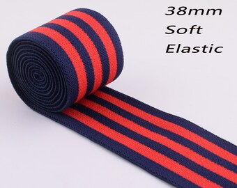 May include: A roll of 38mm soft elastic ribbon. The ribbon is navy blue with three bold red stripes running lengthwise. The text "38mm Soft Elastic" is visible in the image.