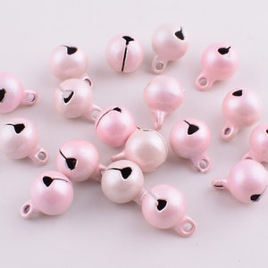 Peut inclure: Un ensemble de 18 petites cloches en m&eacute;tal rose avec une finition argent&eacute;e. Les cloches ont une petite boucle en haut pour les suspendre ou les attacher.