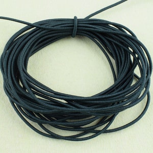 May include: A spool of black elastic cord. The cord is wound tightly and is ready to be used for crafting projects.