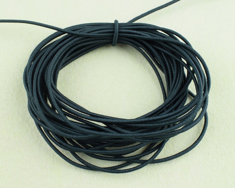 May include: A spool of black elastic cord. The cord is wound tightly and is ready to be used for crafting projects.