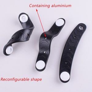 Puede incluir: Tres pulseras de goma negra con extremos de pl&aacute;stico blanco. Las pulseras son reconfigurables y contienen aluminio. El texto "Contiene aluminio" y "Forma reconfigurable" est&aacute; escrito en rojo sobre un fondo blanco.