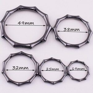 May include: Five black metal rings with a bamboo design. The rings are different sizes, measuring 49mm, 38mm, 32mm, 25mm, and 19mm.