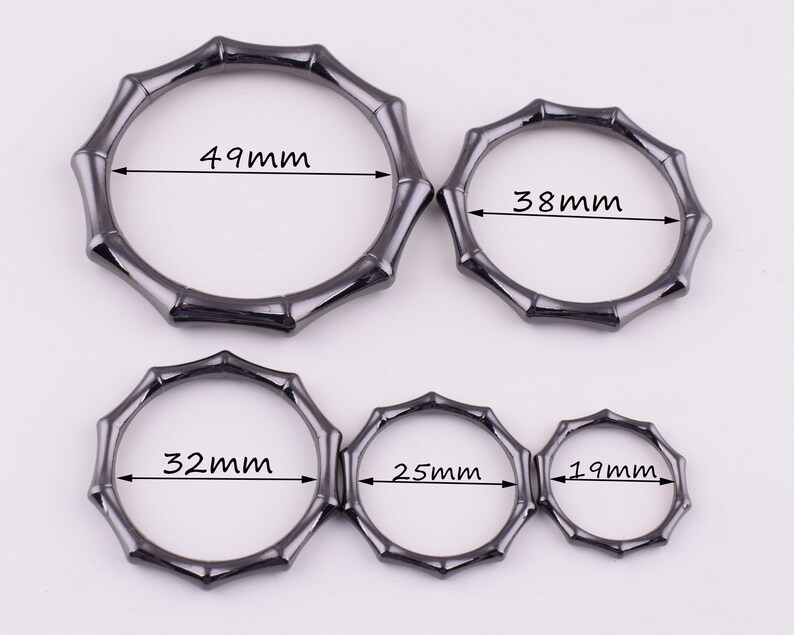 May include: Five black metal rings with a bamboo design. The rings are different sizes, measuring 49mm, 38mm, 32mm, 25mm, and 19mm.