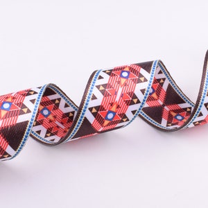 May include: A brown, white, red, and blue patterned ribbon with a geometric design. The ribbon is woven and has a textured surface.