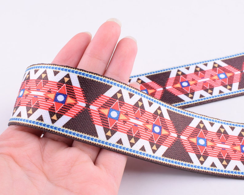May include: Brown, red, white, and blue patterned woven trim with a geometric design.