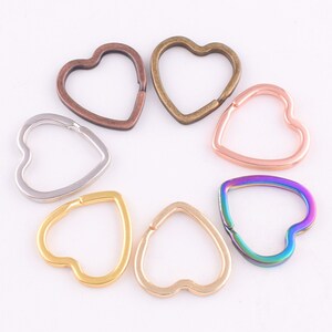 May include: Six heart-shaped key rings in different colours, including silver, gold, bronze, rose gold, and iridescent.