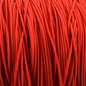 May include: Close-up of a spool of bright red elastic cord. The cord is tightly wound, creating a textured surface. The color is a vibrant, solid red, suitable for various crafting and sewing projects.